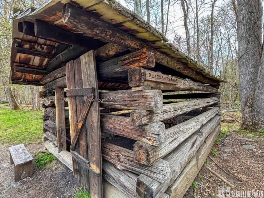 Rustic wooden log structure at Oconaluftee Mountain Farm Museum used as a blacksmith shop.