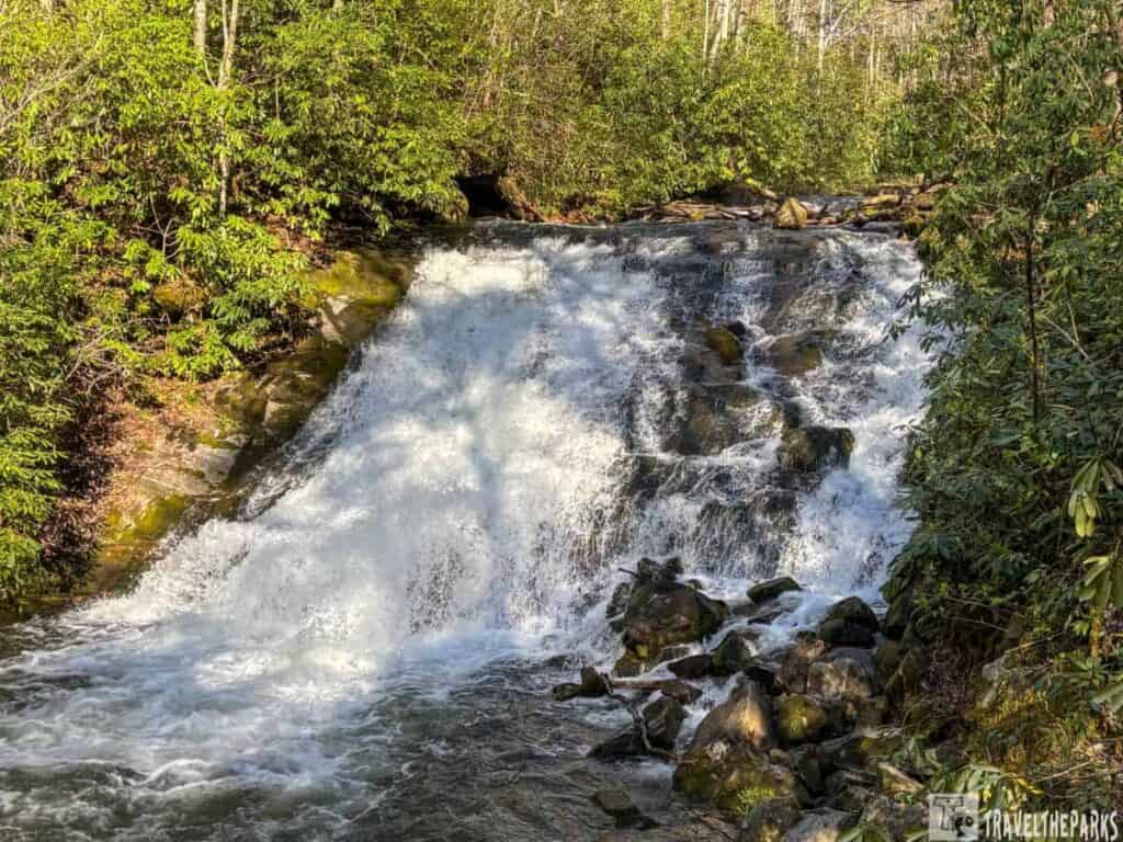 Waterfall at Indian Creek Falls in the Smoky Mountains, surrounded by lush greenery.