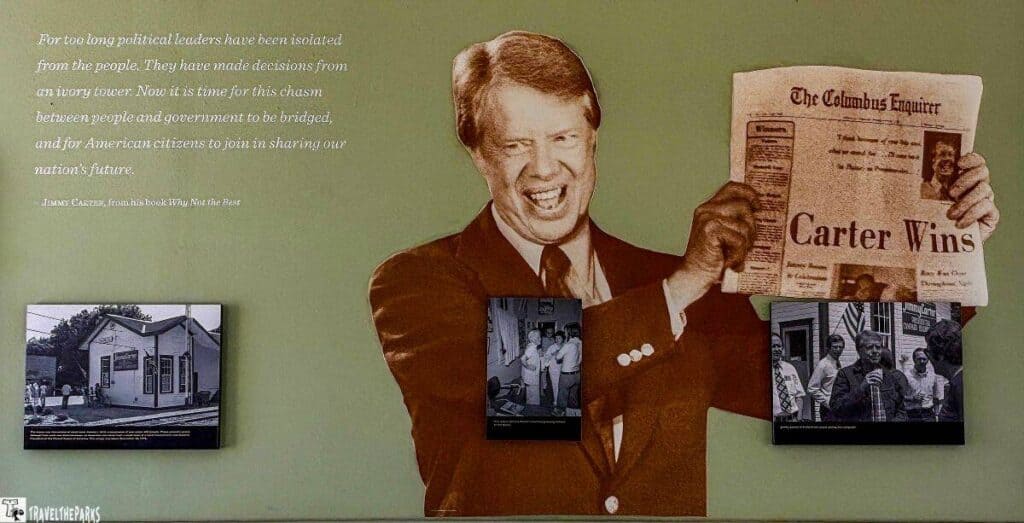 Wall display featuring a large image of Jimmy Carter holding a newspaper with headline "Carter Wins," accompanied by text and three smaller photos.