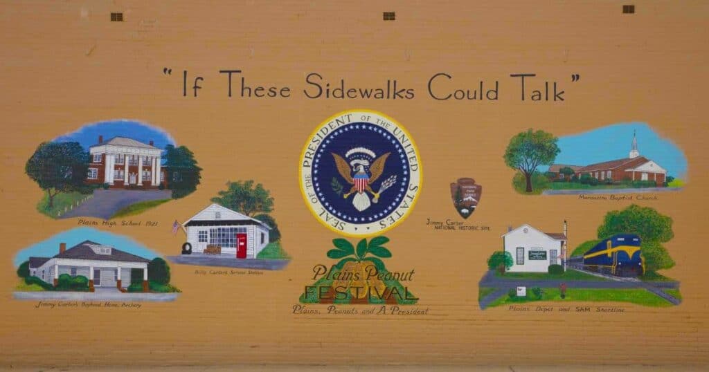 A mural featuring the Seal of the President of the United States and images of historical sites including Plains High School, Billy Carter's Service Station, Jimmy Carter's Boyhood Home, Maranatha Baptist Church, and Plains Depot.