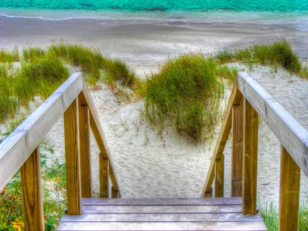A wooden boardwalk leading through dunes to the Gulf of Mexico on the horizon Emerald Coast of Florida on the Emerald Coast.