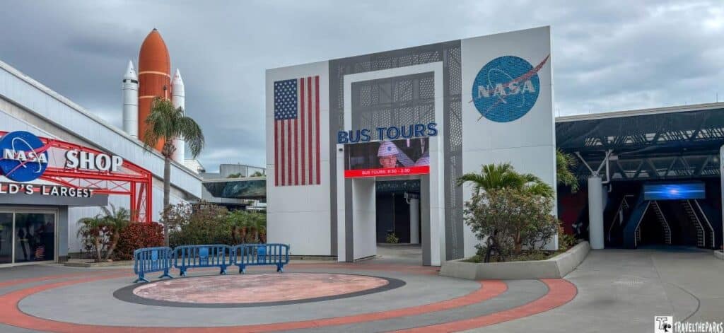 Entrance area to a bus tours facility with the NASA Shop and a rocket display.