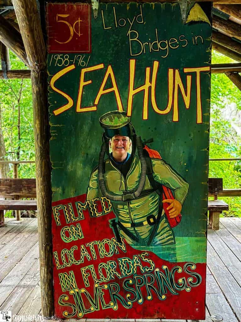 Vintage "Sea Hunt" sign with a face cutout for photos, featuring a diver and promotional text.