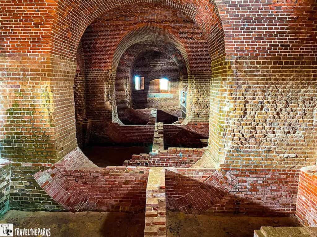 Interior view of a historic brick fort with rounded arches and intricate brick patterns.