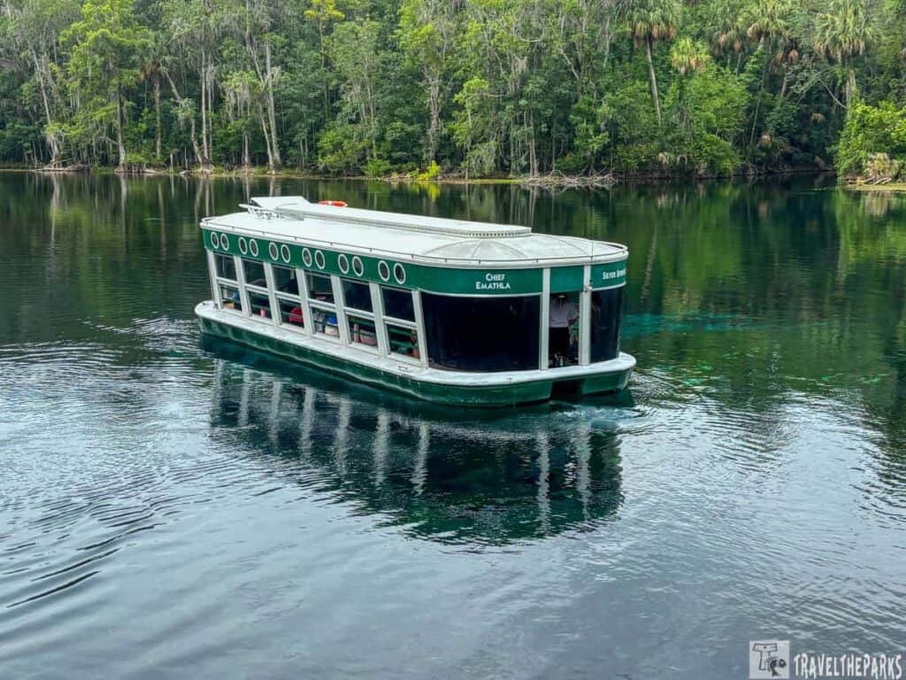 A green glass-bottomed boat on clear water surrounded by trees at Silver Springs State Park.