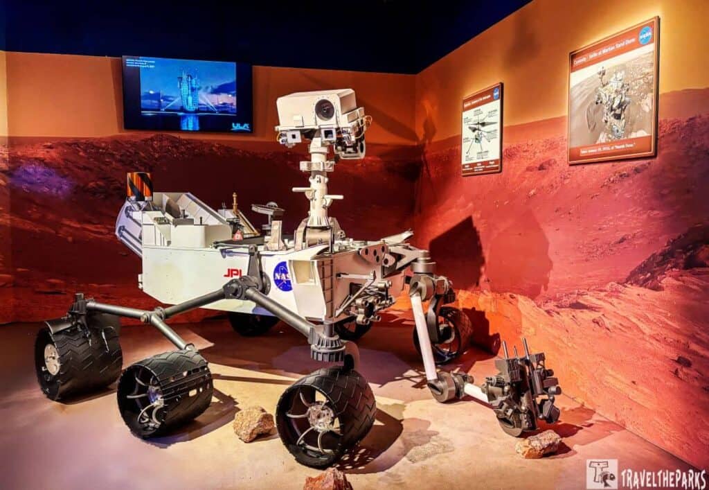 Mars rover exhibit at Kennedy Space Center: Journey to Mars pavilion with Martian landscape background.