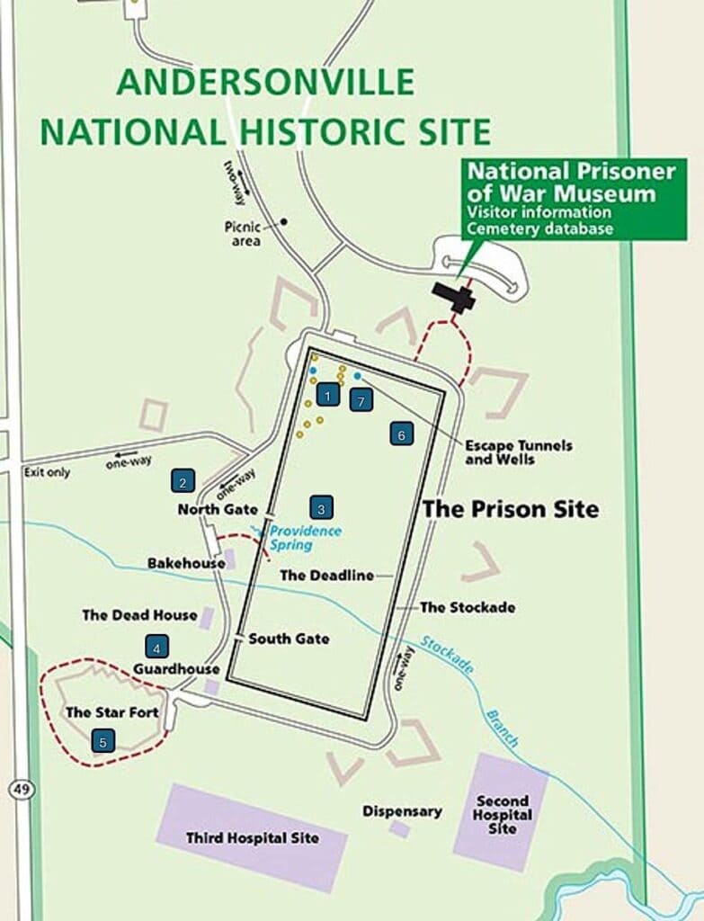 a map of Andersonville National Historic Site, focusing on the layout of The Prison Site. The map primarily uses green, beige, and purple hues for areas and different features. The boundaries of The Prison Site are outlined, with labels for the North and South Gates, The Stockade, The Deadline, and Providence Spring. Key points such as The Dead House, Bakehouse, Guardhouse, and Star Fort are marked and numbered on the map. To the right, the National Prisoner of War Museum is indicated with a green callout box. Nearby areas, such as picnic grounds, escape tunnels, and hospitals, are also labeled. Roads and features are clearly delineated, providing a thorough overview of the location.