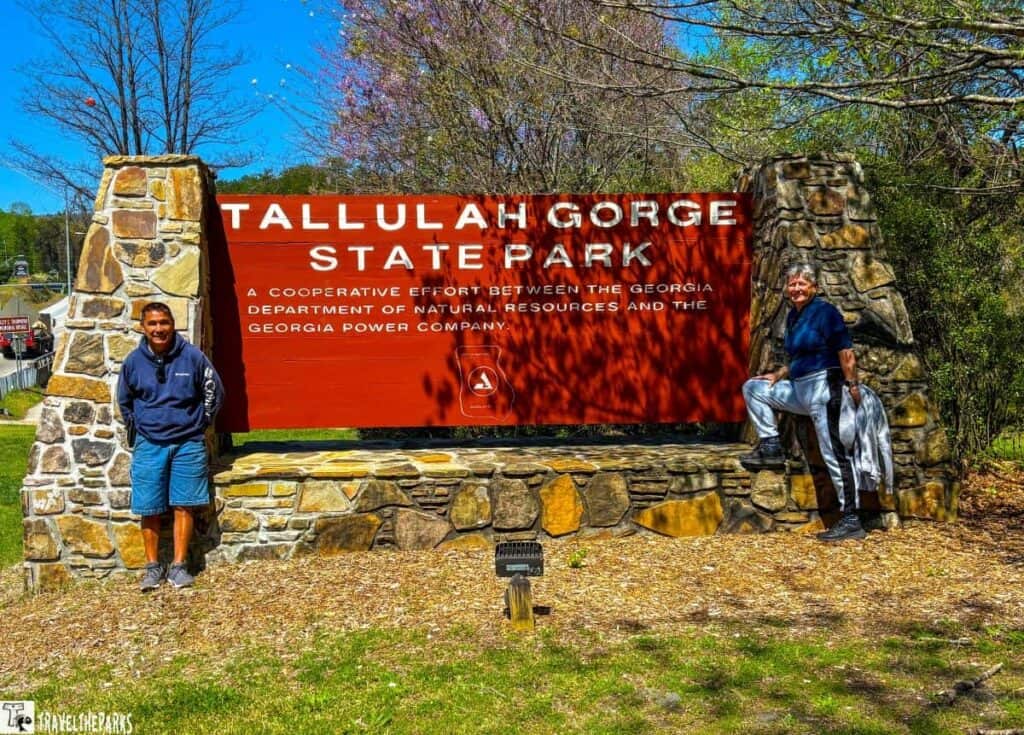 Tallulah Gorge State Park sign with stone pillars and a light fixture in front.