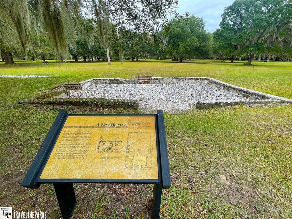 Stone foundation remains at Fort Frederica with an informational plaque in the foreground.
