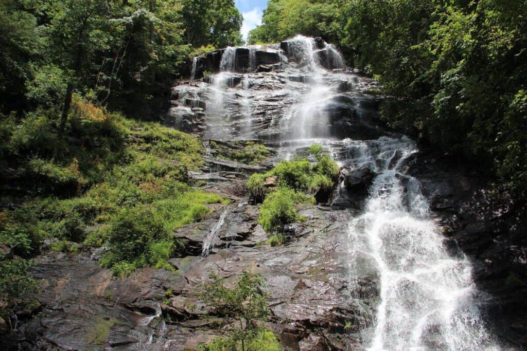 Amicalola Falls cascading down a rocky cliff surrounded by lush greenery.