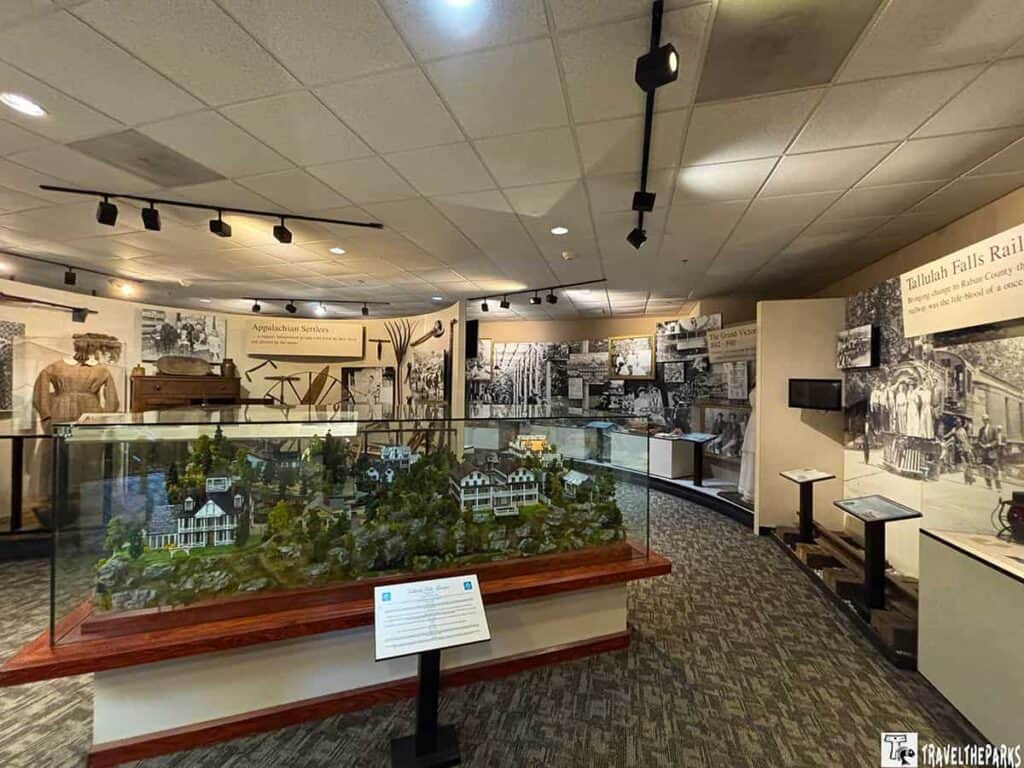 Museum exhibit featuring a scale model of a village, historical photographs, and interpretive panels about Tallulah Falls and Appalachian settlers.