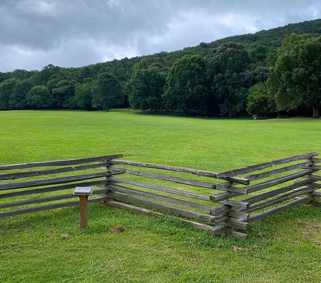 Wooden fence and grassy field at Kennesaw Mountain National Battlefield Park under an overcast sky.