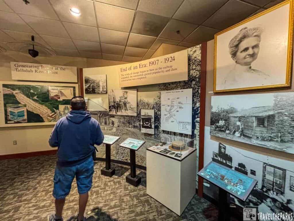 Museum exhibit with historical photos and a person viewing the display.