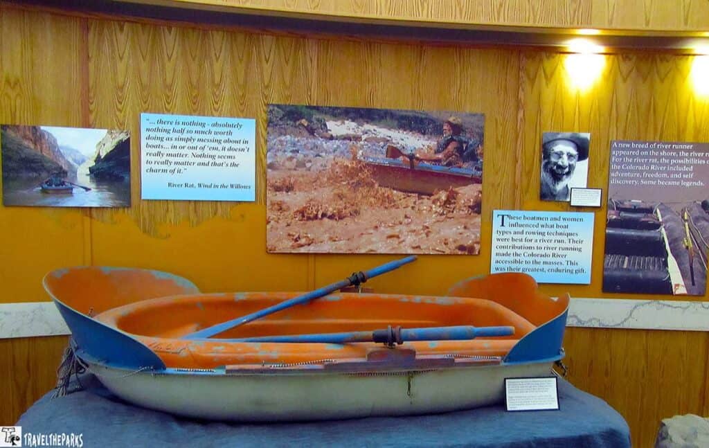 Museum exhibit with an old boat, photos, and text panels related to river boating history.