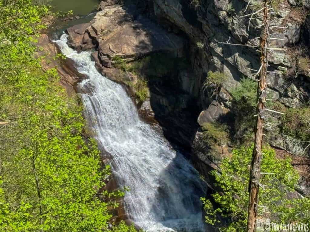 Tempesta Falls cascading down a rock face in Tallulah Gorge, surrounded by green foliage.