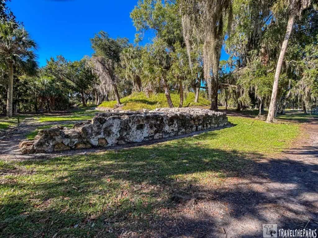Stone ruins and trees at San Marcos de Apalache under a clear blue sky.