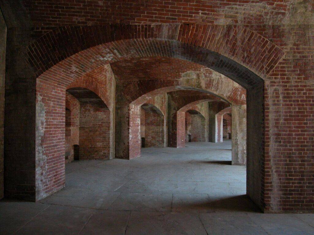 Interior of Fort Massachusetts with brick archways and stone flooring.