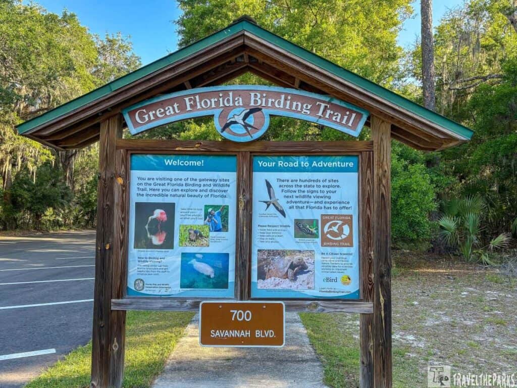 Wooden signboard for the Great Florida Birding Trail at Paynes Prairie Preserve State Park, with information and images about birdwatching sites.