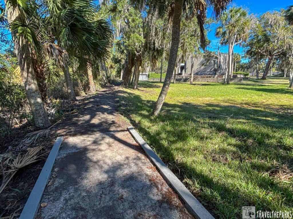 Pathway through palm trees at Fort San Marcos de Apalache with a building in the background.