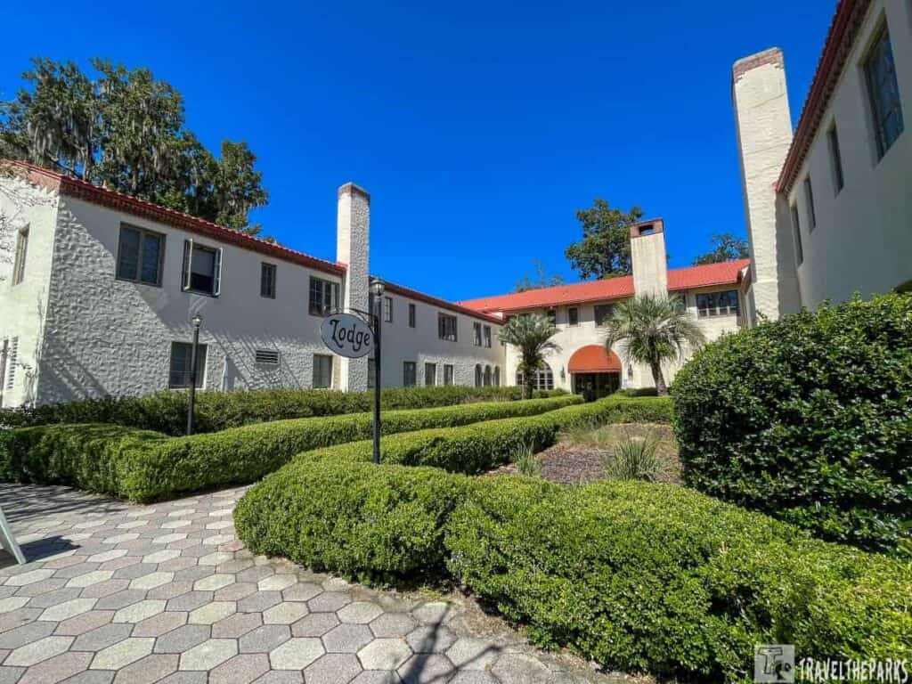 Wakulla Springs Lodge with red-tiled roof, surrounded by trimmed hedges and a clear blue sky.