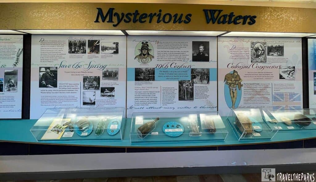 A museum exhibit titled "Mysterious Waters" featuring historical panels and artifact display cases.