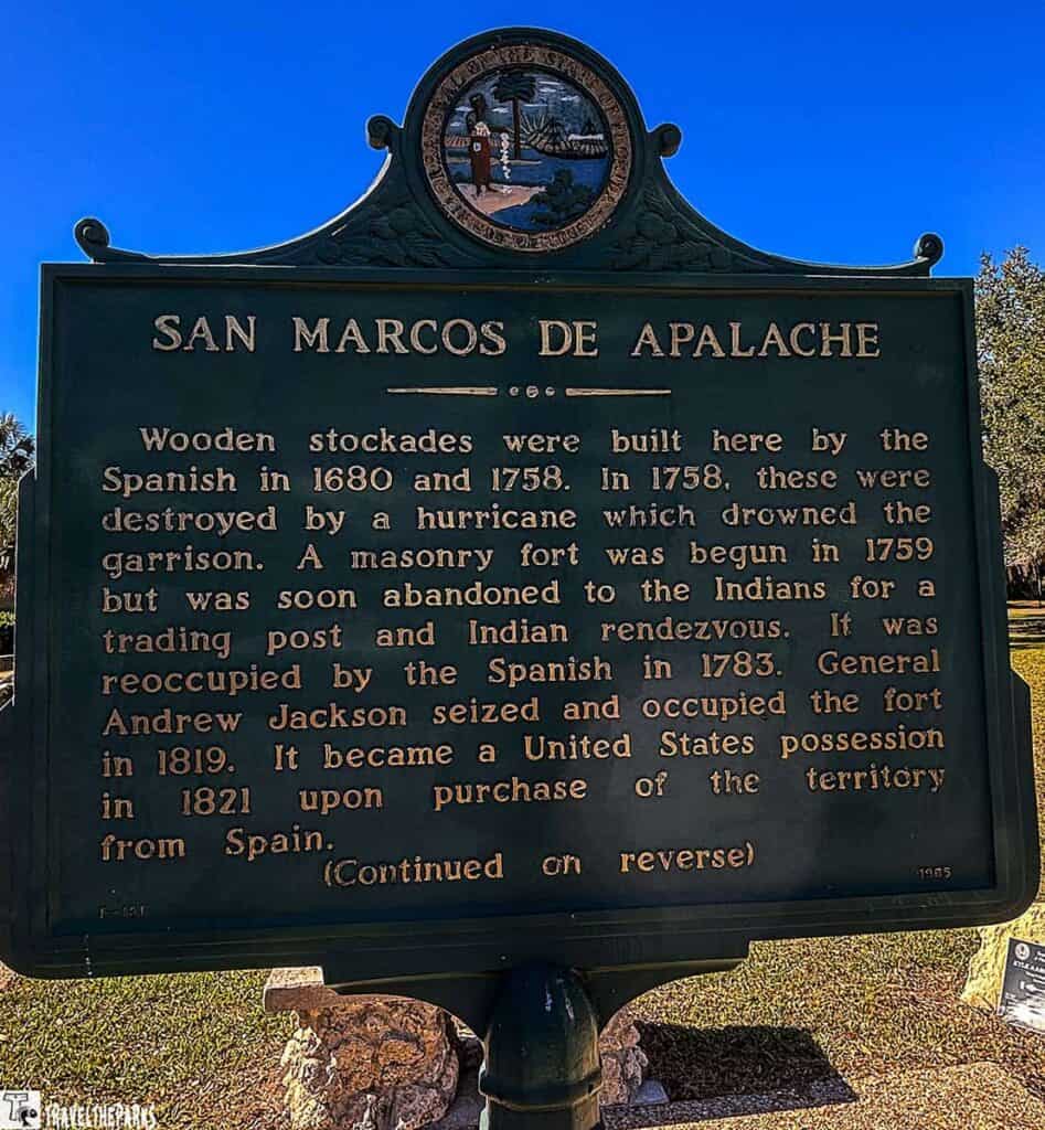 Informational sign about the history of Spanish fortifications on a grassy area.