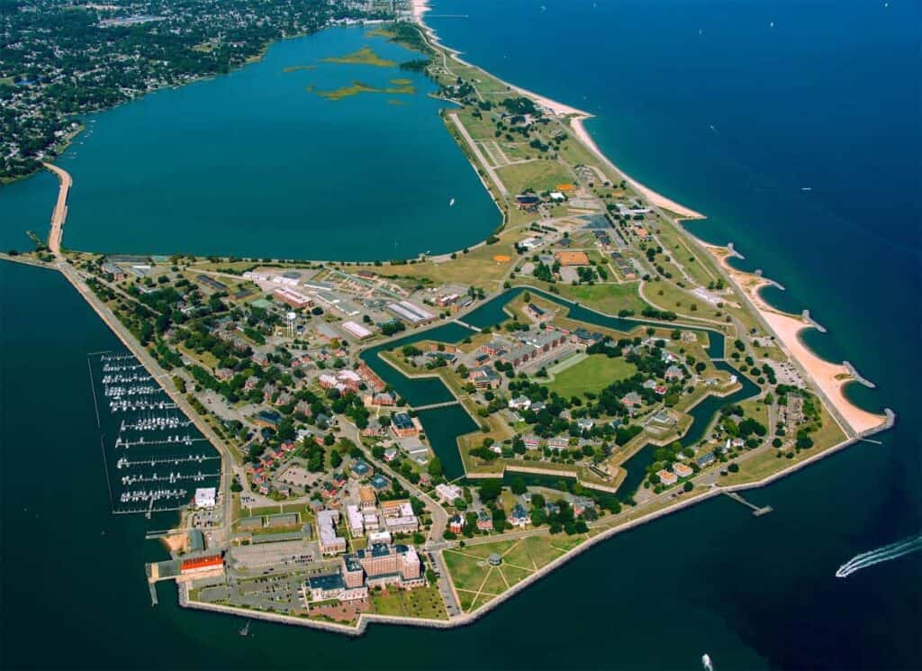 Aerial view of Fort Monroe on a peninsula with star-shaped layout, surrounded by water, buildings, and beaches.