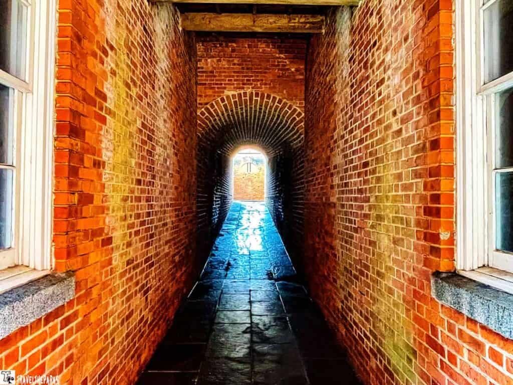 Brick tunnel with arched ceiling at Fort Clinch, leading to an open exit.