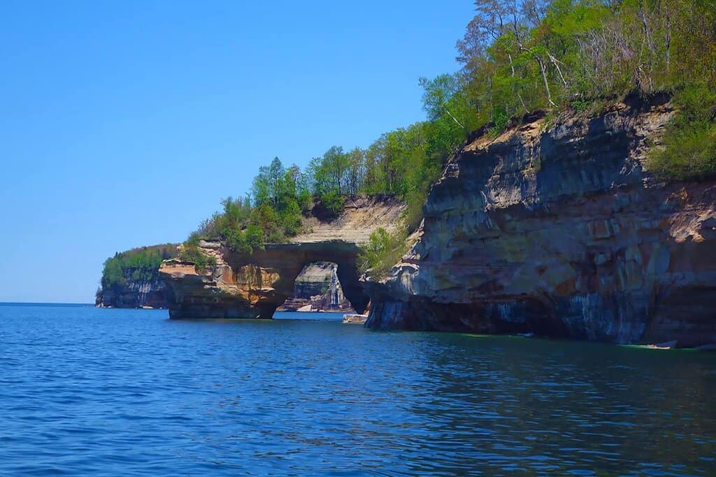 Lover's Leap-Rock cliffs with a natural arch over blue water at Pictured Rocks National Lakeshore.