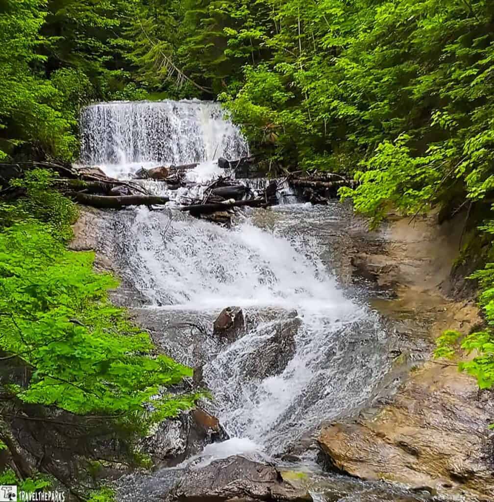 Sable Falls cascading through a lush green forest with multiple rocky tiers.