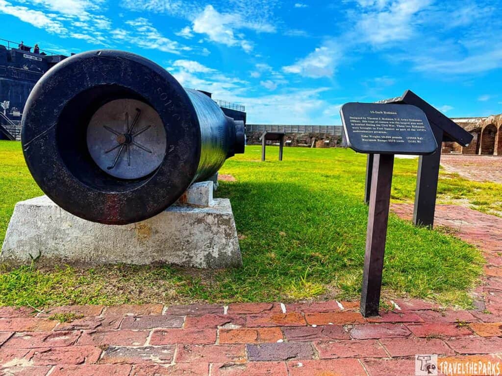 Large black Rodman cannon at Fort Sumter with an informational plaque.