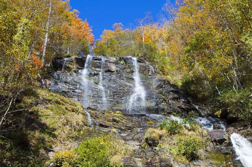 Amicalola Falls with autumn foliage and a bright blue sky.