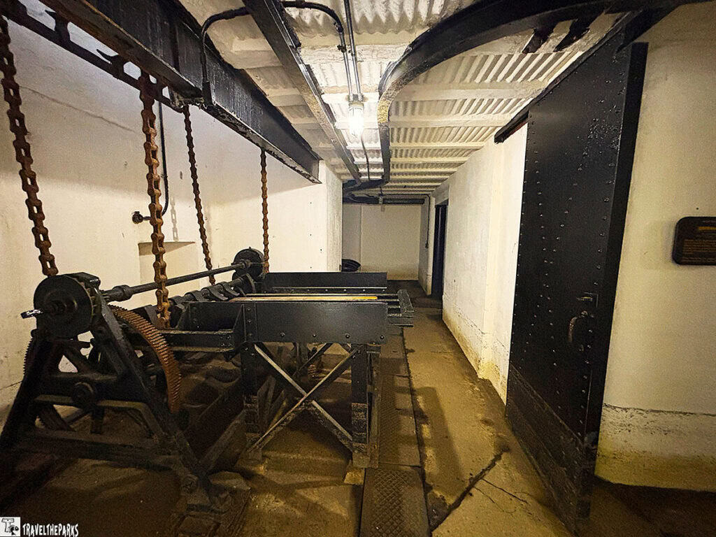 Interior of an artillery lift room with machinery and chains at Battery Jasper, Fort Moultrie. Artillery shells were loaded on this table and hoisted to the upper level of Battery Jasper, Fort Sumter and Fort Moultrie National Historical Park