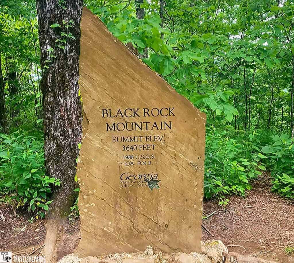 Stone sign for Black Rock Mountain with green foliage in the background.
