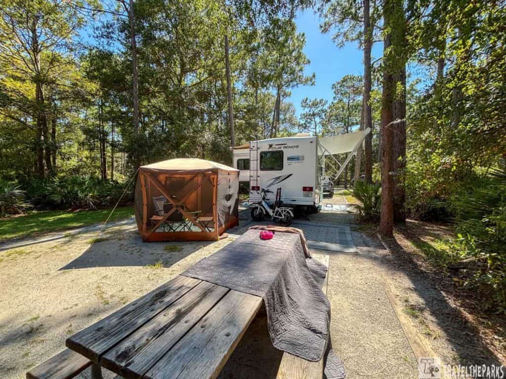 Camping site with RV and tent surrounded by trees at Crooked River State Park.