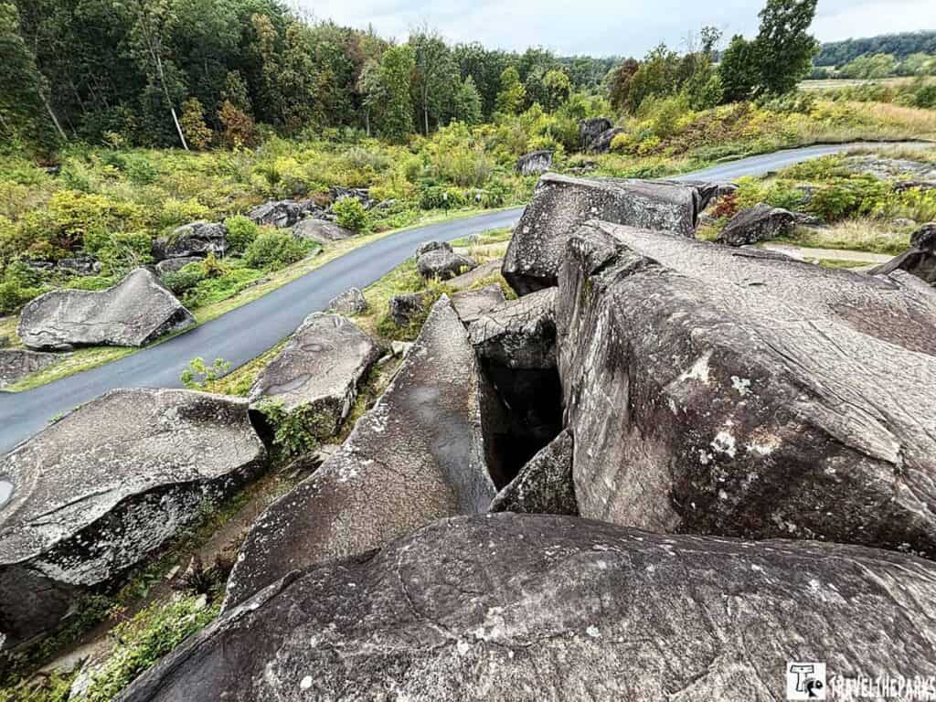 Large boulders and a winding path at Gettysburg National Military Park’s Devils Den, with trees in the background.