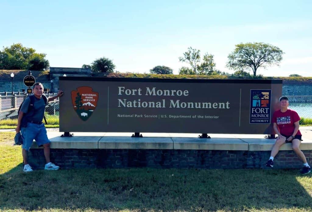 Sign for Fort Monroe National Monument with two people on either side.