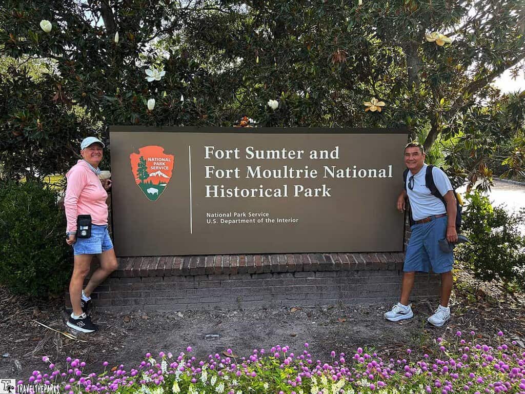 two people in front of the national park sign for Fort Sumter Visitor Center