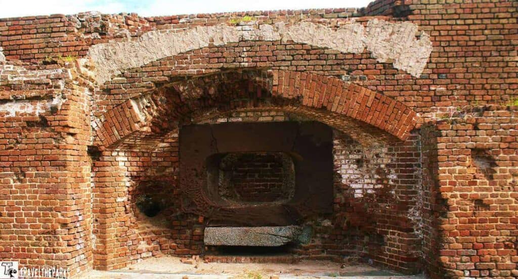 Weathered brick wall with an arched cannon emplacement at Fort Sumter National Monument. Embedded in the left wall is a mortar shell from the battle.