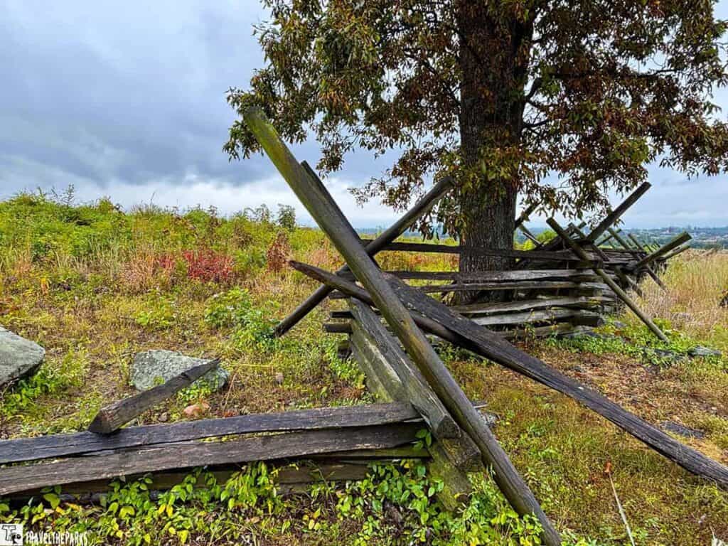 Split-rail fence and tree in Gettysburg National Military Park with overcast sky.