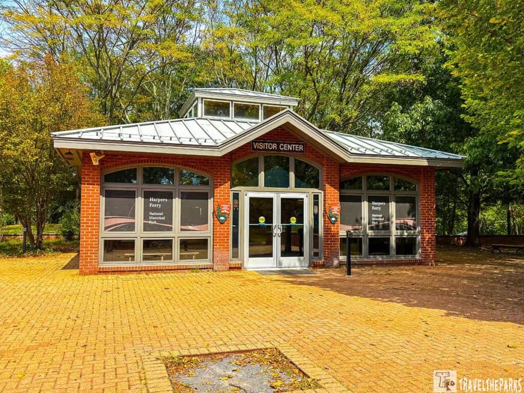 Harpers Ferry Visitor Center with brick facade, large windows, and a gray metal roof.