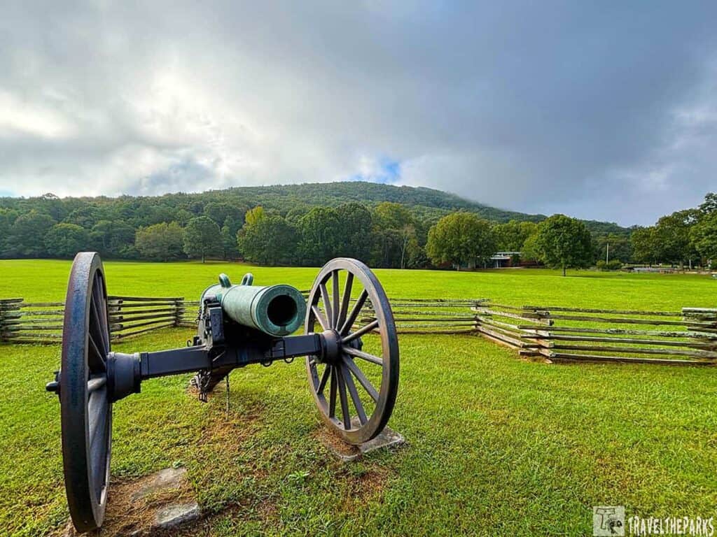 A cannon on a grassy field at Kennesaw Mountain National Battlefield Park, with trees and hills in the background.