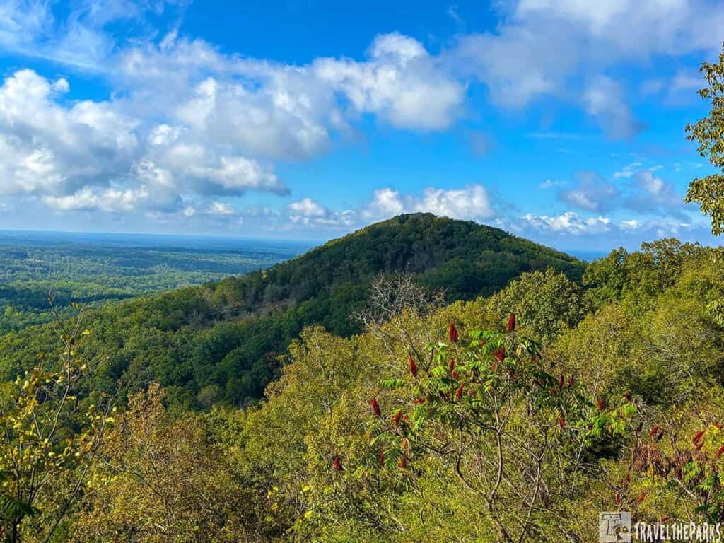 View of Little Kennesaw Mountain with lush greenery under a blue sky with clouds.