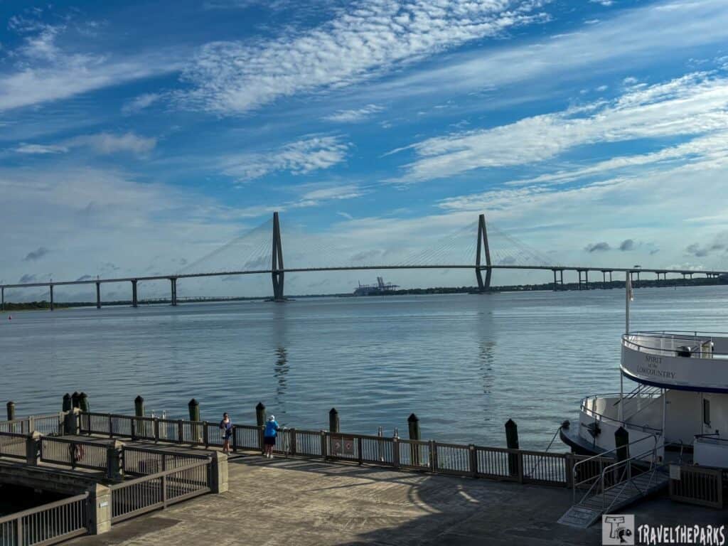 Ravenel-Bridge is a Cable-stayed bridge over a calm body of water with a pier and a docked boat in the foreground.