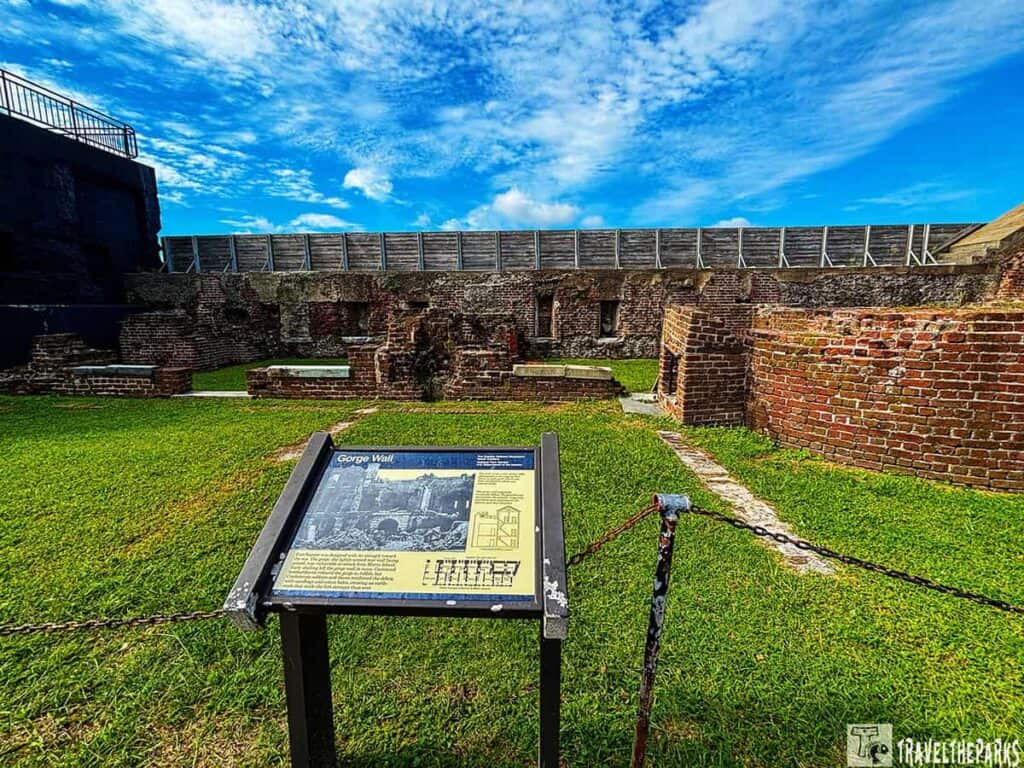 A historic brick wall at Fort Sumter with an informational sign labeled 