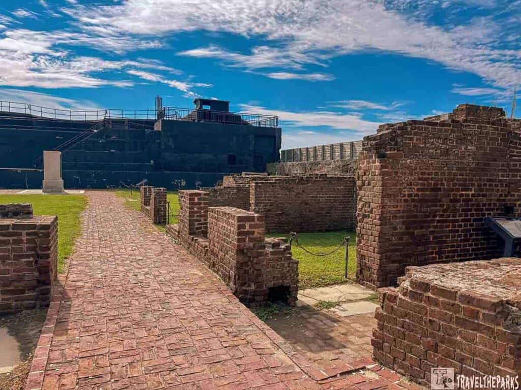 Ruins of Fort Sumter officers' quarters with brick path and fort in the background.