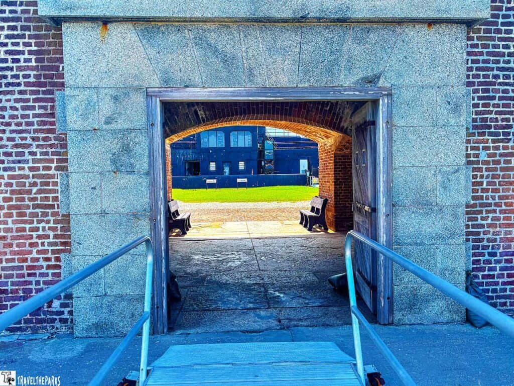 Entrance of a sally port at Fort Sumter with a stone and brick structure and a view of a courtyard.