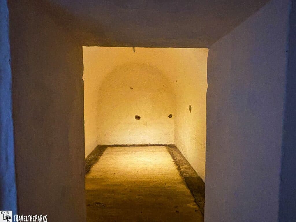 A small, empty Service Magazine room with yellow walls viewed through a doorway at Fort Moultrie.

