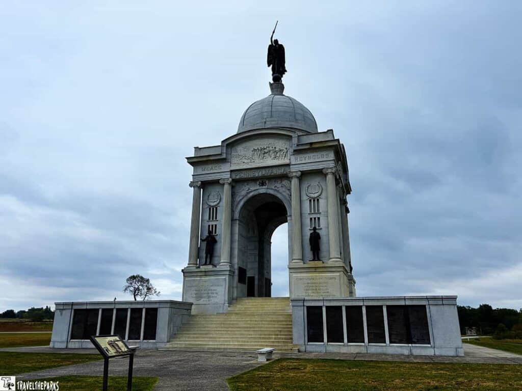 Pennsylvania Monument at Gettysburg National Military Park with a dome and statues against a cloudy sky.