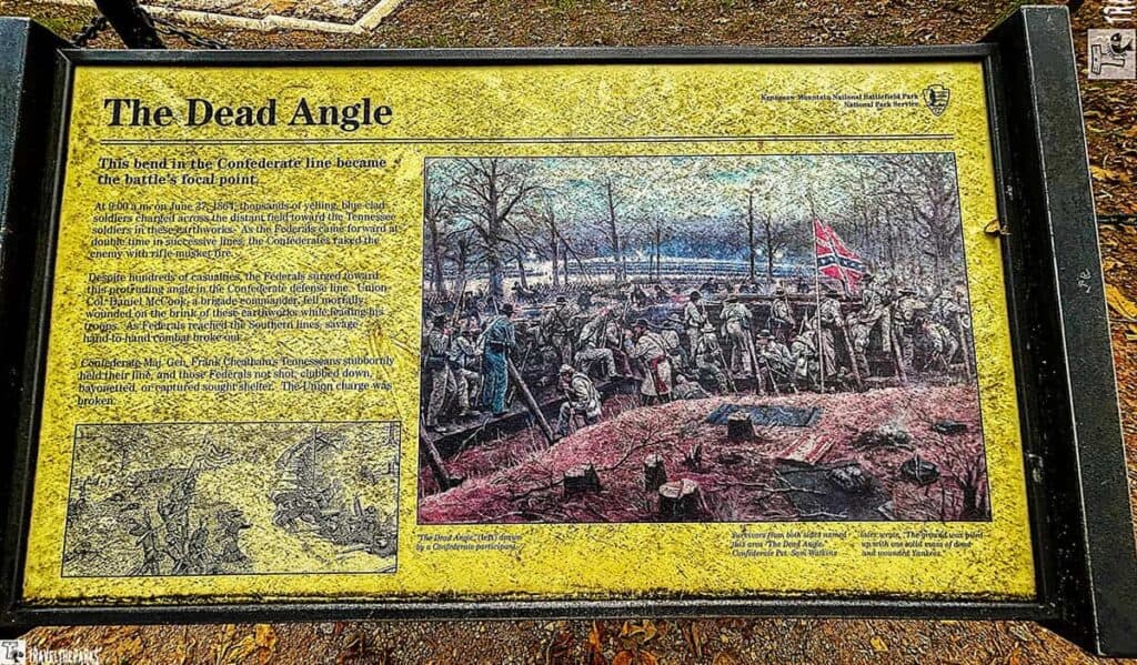 Historical marker titled "The Dead Angle" at Kennesaw Mountain National Battlefield Park, featuring battle text and an illustration of Civil War combat.